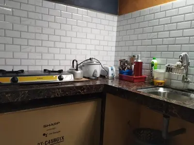 a kitchen counter with a stove and a sink at Inap Desa Jalan Baru in Kampong Sedim Number Two