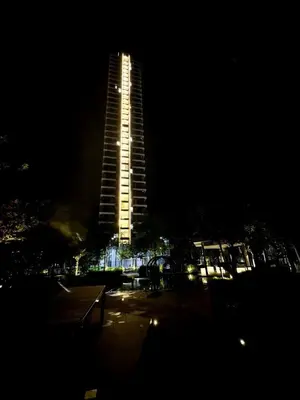 a tall building is lit up at night at sea city cozy familystay 3br 10 pax in George Town