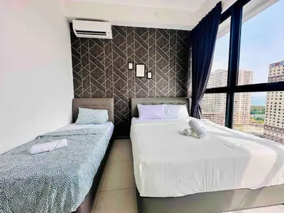 two beds in a room with a window at Urban suites 3BR 10pax in George Town