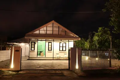 a small white house with a gate at night at Stay SongSong Mount Erskine in George Town