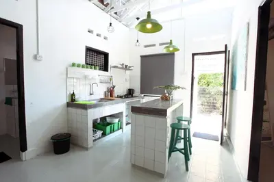 a kitchen with white walls and a counter with green stools at Stay SongSong Mount Erskine in George Town