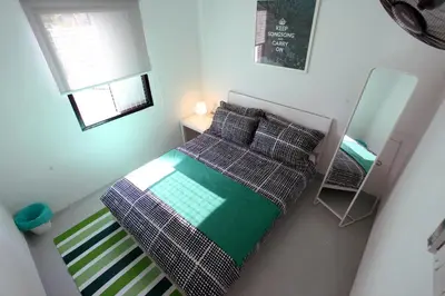 a small bedroom with a bed and a mirror at Stay SongSong Mount Erskine in George Town