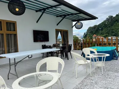 a patio with white chairs and a white table and chairs at Hillview Bercham Height CoLiving Villa in Ipoh