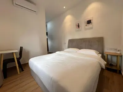 a bedroom with a large white bed and a desk at Hillview Bercham Height CoLiving Villa in Ipoh