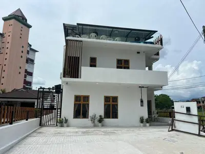 a white house with a balcony on top of it at Hillview Bercham Height CoLiving Villa in Ipoh