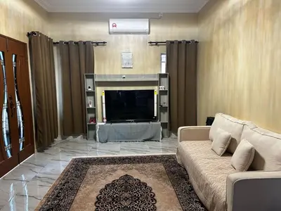 a living room with a couch and a flat screen tv at Ariana Homestay in Sekincan