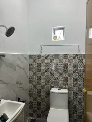 a bathroom with a white toilet and a sink at Ariana Homestay in Sekincan