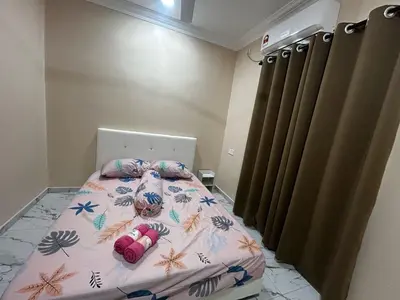 a bedroom with a bed with a floral bedspread at Ariana Homestay in Sekincan