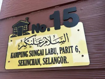a sign on the side of a building at Ariana Homestay in Sekincan