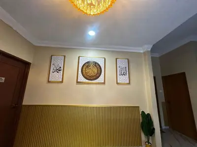 a room with three pictures on the wall and a chandelier at Ariana Homestay in Sekincan