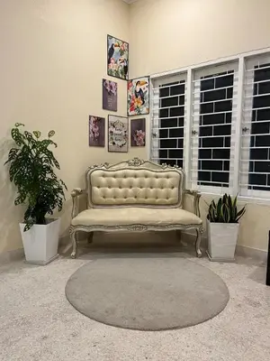 a couch sitting in a room with pictures on the wall at 728 NanasHomes Little Bungalow in Ipoh 10 pax in Ipoh