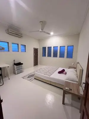 a white bedroom with a bed and a desk at 728 NanasHomes Little Bungalow in Ipoh 10 pax in Ipoh