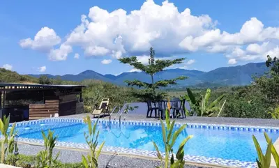 a swimming pool with mountains in the background at CBHResort Agrofarm in Baling