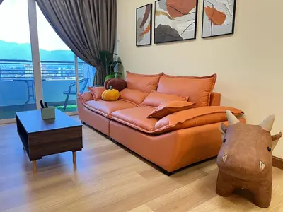 a living room with a brown leather couch and a table at G Home 2 - Ipoh City Centre The Majestic 2R2B in Ipoh