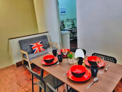 a wooden table with red plates and glasses on it at Queensbay Mall, Up to 6 Pax, 3 Bedrooms, 2 Bathrooms, 1 Car Park by Star Home in Bayan Lepas