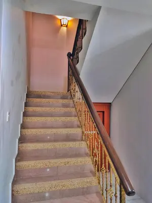 a staircase with wooden railings and a white wall at Semi-Detached, Up to 24 Pax, 3200sqft, 4 Bedrooms, 3 Bathrooms, 4 Car Parks by Star Home in Gelugor