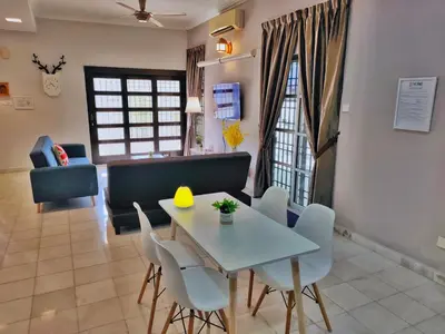 a dining room and living room with a table and chairs at Semi-Detached, Up to 24 Pax, 3200sqft, 4 Bedrooms, 3 Bathrooms, 4 Car Parks by Star Home in Gelugor