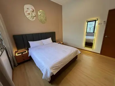 a bedroom with a white bed and a clock on the wall at Kaka Pool Homestay TmnIntan EventAllowed in Sungai Petani