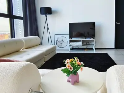 a living room with a couch and a vase with flowers at Near Georgetown with Beautiful city view 2 room fit 4 to 7 pax in Jelutong