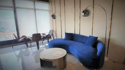 a living room with a blue couch and a table at Near Georgetown with Beautiful city view 2 room fit 4 to 7 pax in Jelutong