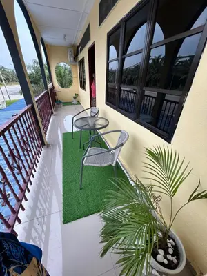 a balcony with a table and a chair and a plant at Chengai homestay in Sungkai