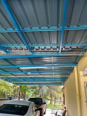 a carport with a blue ceiling with cars parked under it at Chengai homestay in Sungkai