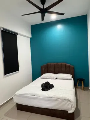 a bedroom with a bed with a blue wall at Lavender Villa Marc Residence Bukit Mertajam in Bukit Mertajam