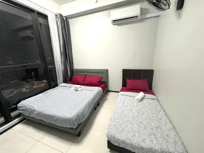 two beds in a room with a window at Royal Luxury apartment in Georgetown 3BR 10PAX in George Town