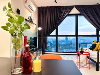 a living room with a table with a vase of flowers at The society Apartment George town 3br 10 pax in George Town