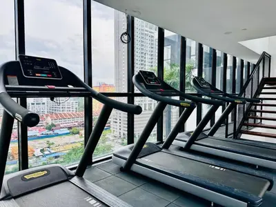 a row of treadmills in a gym with a window at Sea & City View New Condo in Georgetown 3br 10 pax in George Town