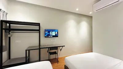 a bedroom with a bed and a desk with a tv at Legend Inn Sungai Petani in Sungai Petani