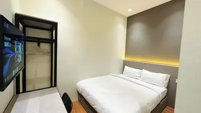 a bedroom with a bed and a flat screen tv at Legend Inn Sungai Petani in Sungai Petani