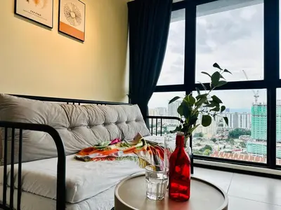 a living room with a couch and a large window at cozy family stay suites apartment 3br 10 pax in George Town