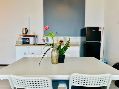 a white table with a vase with flowers on it at cozy family stay suites apartment 3br 10 pax in George Town