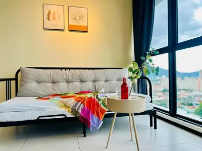 a bedroom with a bed and a table and a window at cozy family stay suites apartment 3br 10 pax in George Town