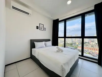 a bedroom with a large bed with a large window at cozy family stay urban suite 3br 10 pax in George Town