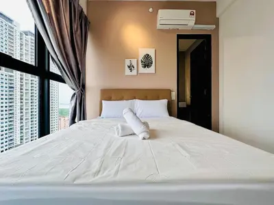 a bedroom with a large white bed with a window at cozy family stay urban suite 3br 10 pax in George Town