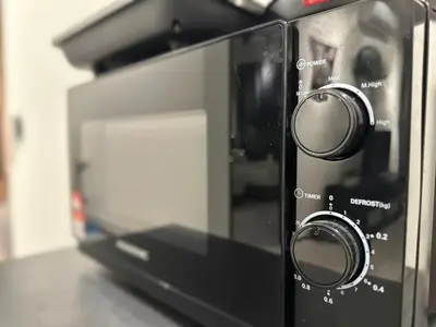 a microwave oven with twoobs on top of a counter at cozy family stay urban suite 3br 10 pax in George Town