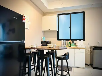a kitchen with a table and some stools in it at cozy family stay urban suite 3br 10 pax in George Town