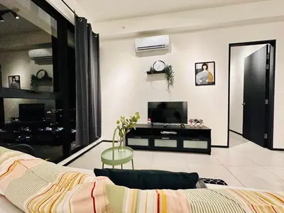 a living room with a couch and a tv and a table at luxury apartment 3br 10 pax in George Town