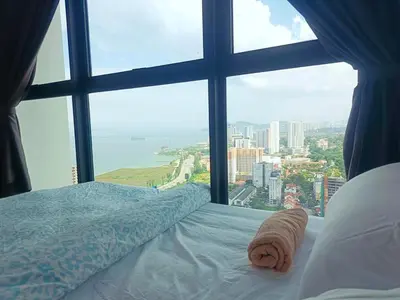 a bed in a room with a large window at Infinity pool luxury apartment suites 3br 10 pax in George Town