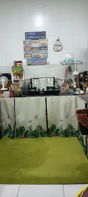 a kitchen with a table with a green floor at HEE & PENNIE House in Ipoh
