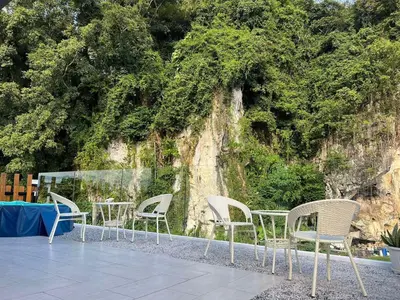 a group of chairs and tables in front of a wall at Hillview Ipoh in Ipoh