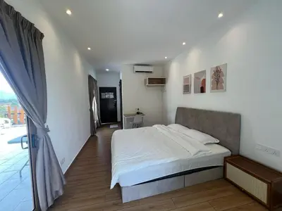 a bedroom with a white bed and a balcony at Hillview Ipoh in Ipoh