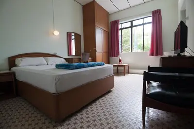 a bedroom with a large bed and a window at Peking Hotel in George Town