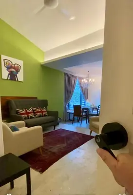 a person holding a remote control in a living room at Ipoh Garden Canning Very Near Food Desire Homestay in Ipoh