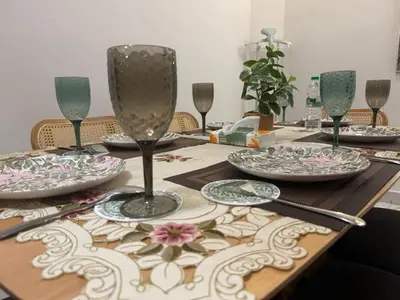 a table with plates and wine glasses on it at Zhara Homestay in Ipoh