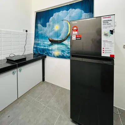a room with a refrigerator and a painting on the wall at Ipoh Garden 5 Homestay in Ipoh