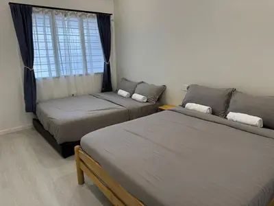 two beds in a room with a window at Ipoh Garden 5 Homestay in Ipoh