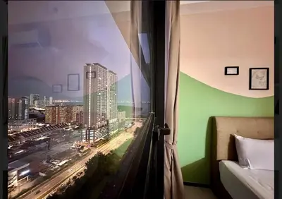 a room with a window with a view of a city at Luxury suites UB 3br 10 pax in Jelutong
